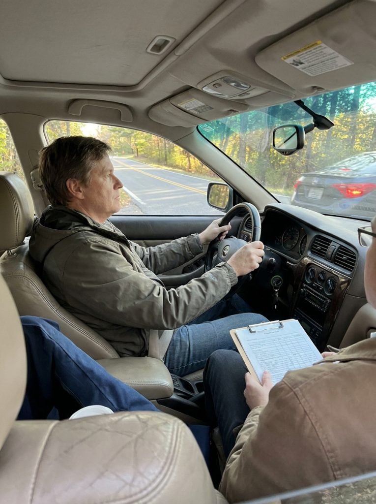 How to Test Drive a Used Car Like a Pro: 10 Smart Steps for 2026 2 This image shows a buyer testing brakes and steering during a used car test drive, supporting the section about brake response, vibration, pulling, steering feel, and handling.